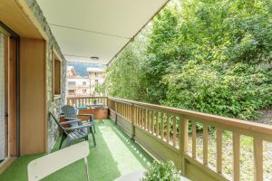 a balcony with two chairs and a tree at Bourg Saint Maurice Centre 45m2 prox Gare SNCF et Funiculaire in Bourg-Saint-Maurice