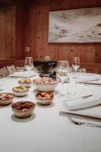 una tavola con piatti di cibo e bicchieri di vino di Das Verwall - finest serviced apartments a Lech am Arlberg