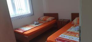 2 camas individuais num pequeno quarto com uma janela. em Apartman Andjela em Sokobanja