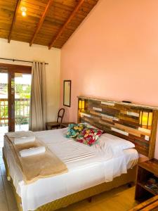 a bedroom with a large bed in a room at Rosamar Suites in Praia do Rosa