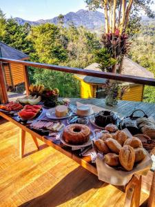 a table filled with different types of food on a deck at Pousada Mirante do Céu in Visconde De Maua