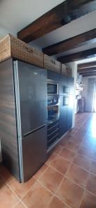 a kitchen with a stainless steel refrigerator and a tile floor at Apartamento Callentum (Cazalla de la Sierra) in Cazalla de la Sierra