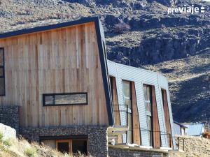 a building with wooden siding on the side of a mountain at Solo Lofts in El Chalten