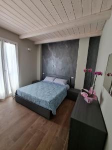 a bedroom with a bed and a table with flowers at Alloggi di porta po in Cremona