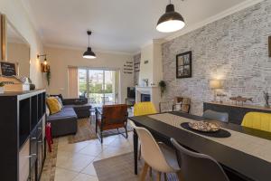 uma cozinha e sala de estar com mesa e cadeiras em Real Alegria - Terrace with pool - Vilamoura em Vilamoura