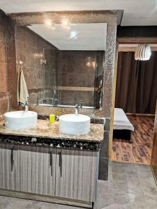 a bathroom with two sinks and a large mirror at Magnifique Villa a Savannah Beach in Sidi Rahal