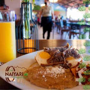 特皮克的住宿－Casa Naiyari，一杯橙汁旁边的餐桌上的食物