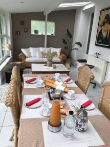 una sala da pranzo con tavolo e divano di Séverine chambres d’hôtes a Floing