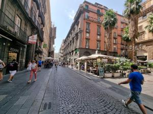 una strada di ciottoli in una città con gente che cammina su di essa di BARBAJA SUITES IN STREET TOLEDO 205 a Napoli