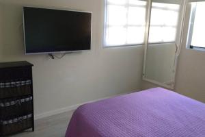 a bedroom with a bed and a flat screen tv at Departamento frente al mar in Santa Teresita