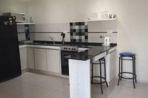a kitchen with a stove and a sink and a refrigerator at Departamento frente al mar in Santa Teresita +1 photo