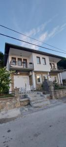 a large white house with chairs and a porch at Apartment - NANE - Krushevo in Kruševo