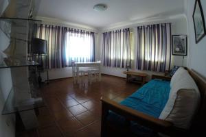 a living room with a bed and a table at Sesimbra - Casa na Praia (Reg.97616/AL) in Sesimbra