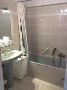 een badkamer met een bad, een wastafel en een bad bij Superbe Studio parking piscine in Nice