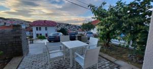 a table and chairs on a patio with a view of a city at Apartman Nane 2 in Kruševo
