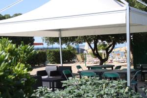 a white pavilion with chairs and tables in a garden at La Marina Bay in Vieste