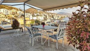 a table and chairs with a view of a harbor at Joen Apartments in Sarandë