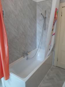 uma casa de banho com banheira e chuveiro em Kirkhouse em Wick