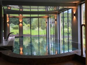 a pool in the middle of a house with glass doors at Oasis Resort & Spa in Rewal