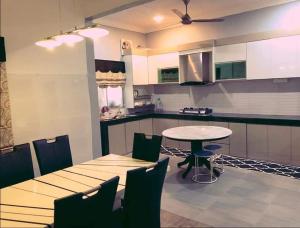 a kitchen with a table and chairs in a room at Homestay Dferry Jerantut Fully Aircond in Jerantut