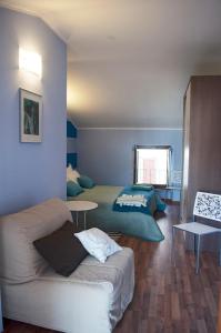 uma sala de estar com duas camas e um sofá em Di-vinodormire em La Morra