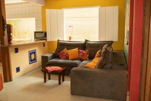 uma sala de estar com um sofá cinzento com almofadas coloridas em Hostel Morada do sol Paraty em Paraty
