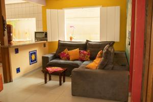 a living room with a gray couch with colorful pillows at Hostel Morada do sol Paraty in Paraty