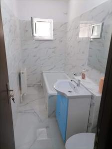 La salle de bains blanche est pourvue d'un lavabo et de toilettes. dans l'établissement HomeAway, à Bacău