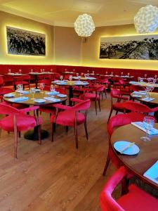 a restaurant with tables and chairs and red chairs at The Park Hotel in Liverpool