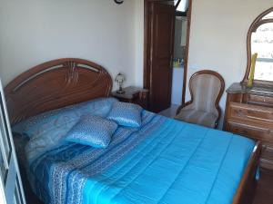 een bed met blauwe lakens en kussens in een slaapkamer bij Casa do Terço in Câmara de Lobos