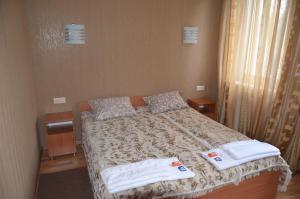 1 dormitorio con 1 cama con toallas en Atlant Hotel, en Ostroh