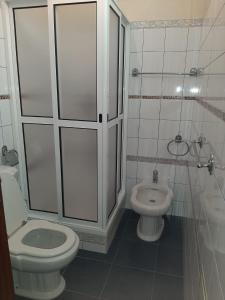 een witte badkamer met een toilet en een wastafel bij Casa do Terço in Câmara de Lobos