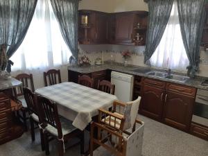 a kitchen with a table and chairs and a sink at Casa do Terço in Câmara de Lobos