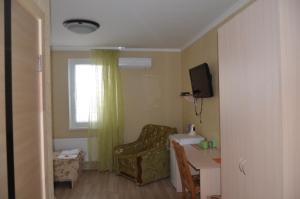 um quarto com uma cadeira, uma mesa e uma janela em Atlant Hotel em Ostroh