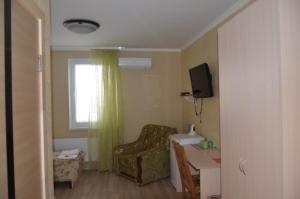 a room with a chair and a table and a window at Atlant Hotel in Ostroh