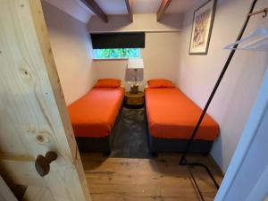a small room with two beds and a window at Vakantieverblijf Perron 3 in Haarle