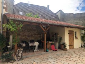 a patio with a roof and a table and chairs at Ferienwohnung Oma Else in Offenheim +21 photos