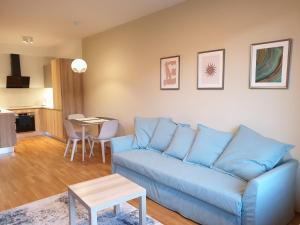 a living room with a blue couch and a table at Costas apartments in Prague