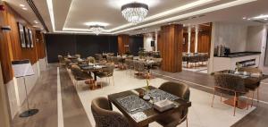 a restaurant with tables and chairs in a room at Lilac Hotel - Amman in Amman