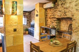 a dining room with a wooden table and a stone wall at CALA VELLA Casa Vacacional RURAL in Bocairent +25 photos