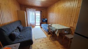 a living room with a couch and a table at Wellapartman Zamárdi in Zamárdi