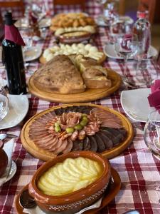 a table topped with plates of food and glasses of wine at Hotel Pavlović in Žabljak