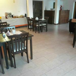 メルロにあるHotel posada barrancas del solの木製のテーブルと椅子のあるダイニングルーム