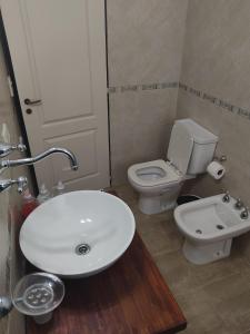 メルロにあるHotel posada barrancas del solの白い洗面台とトイレのあるバスルーム