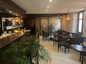 a restaurant with a bar and tables and chairs at Hôtel D’Artiste in Pierrefontaine-les-Varans