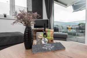 a vase with flowers on a table in a living room at Apartman Enjoy Nin in Nin