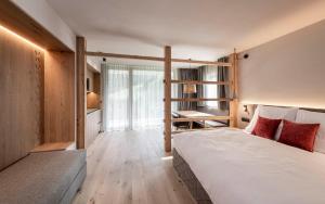 ein Schlafzimmer mit einem Bett und einem großen Fenster in der Unterkunft Residence Le Fostü in St. Vigil