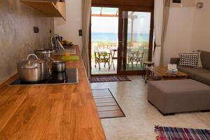 eine Küche und ein Wohnzimmer mit einem Sofa und einem Tisch in der Unterkunft Horizonte Seafront Suites in Kissamos
