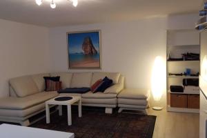 ein Wohnzimmer mit einem Sofa und einem Tisch in der Unterkunft 2 Zimmer-Einliegerwohnung am Flughafen Schönefeld in Berlin
