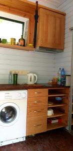 uma cozinha com uma máquina de lavar roupa e uma máquina de lavar roupa em Forest Hut em Bigauņciems